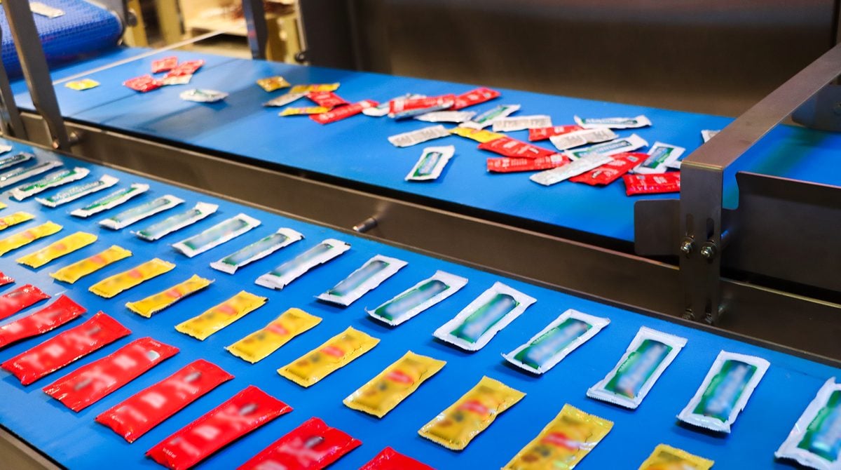 JLS Vision AI demo cell: mixed condiment packets on the infeed conveyor are organized into pick-ready rows by type and orientation